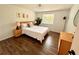 Bright bedroom featuring hardwood floors, neutral walls, tropical decor, and natural light at 1503 Edna Ave Nw, Largo, FL 33770