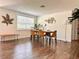 Dining area showcasing sleek hardwood floors and abundant natural light from a bright window at 1503 Edna Ave Nw, Largo, FL 33770