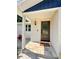 Charming front porch with brick facade, stylish door, welcome mat and outdoor lighting at 1503 Edna Ave Nw, Largo, FL 33770
