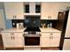 Contemporary kitchen with white cabinetry, stylish backsplash, and stainless steel appliances at 1503 Edna Ave Nw, Largo, FL 33770