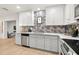 Modern kitchen with white cabinets, stainless steel appliances, and geometric backsplash at 2436 Lighthouse Dr, Palm Harbor, FL 34685