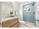 Modern bathroom with marble vanity and a blue-tiled shower at 2436 Lighthouse Dr, Palm Harbor, FL 34685