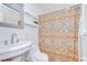 Cozy bathroom features a colorful shower curtain and vanity sink with a bright light at 5210 Newton S Ave, Gulfport, FL 33707