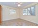 This bedroom features wood-look floors, neutral paint, a ceiling fan, and two windows with natural light at 5210 Newton S Ave, Gulfport, FL 33707
