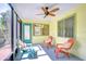 Relaxing screened porch with comfortable seating, ceiling fan, and access to the outdoors at 5210 Newton S Ave, Gulfport, FL 33707
