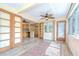 Bright sunroom with wood-look floors, ceiling fan, and doors that lead to kitchen and outside at 5210 Newton S Ave, Gulfport, FL 33707