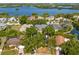 Picturesque aerial view of a quiet neighborhood nestled among lush trees and a tranquil lake, creating a peaceful living environment at 5841 Bay Pines Lakes Blvd, St Petersburg, FL 33708