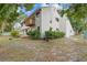 Charming home exterior with a cozy wooden balcony and a lush, green backyard, creating a serene retreat at 5841 Bay Pines Lakes Blvd, St Petersburg, FL 33708