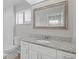 Bathroom vanity with white cabinets, granite countertop, framed mirror, and new fixtures at 5841 Bay Pines Lakes Blvd, St Petersburg, FL 33708