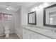 Bright bathroom featuring double sink with granite countertop and decorative mirrors at 5841 Bay Pines Lakes Blvd, St Petersburg, FL 33708
