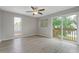 A bedroom with wood-look flooring, ceiling fan, and sliding glass door access to the balcony at 5841 Bay Pines Lakes Blvd, St Petersburg, FL 33708