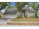 Charming home with manicured lawn, mature trees, and large window accents for natural light at 5841 Bay Pines Lakes Blvd, St Petersburg, FL 33708