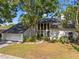 Exterior shot featuring attached garage, landscaping, and modern window design for natural light at 5841 Bay Pines Lakes Blvd, St Petersburg, FL 33708
