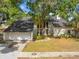 Home with attached garage, landscaped yard, and modern window design for abundant natural light at 5841 Bay Pines Lakes Blvd, St Petersburg, FL 33708