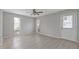 Bright living room featuring wood-look floors, ceiling fan, and natural light from the windows and door at 5841 Bay Pines Lakes Blvd, St Petersburg, FL 33708