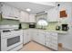 Well-lit kitchen featuring white cabinetry and modern appliances at 7787 39Th N Ter # 7787, St Petersburg, FL 33709