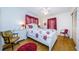 Bright main bedroom is furnished with floral bedding, bedside tables, and wood floors at 7787 39Th N Ter # 7787, St Petersburg, FL 33709