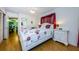 Main bedroom includes wood floors, a closet, floral accents and decorative red curtains at 7787 39Th N Ter # 7787, St Petersburg, FL 33709