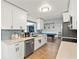 Modern kitchen with white cabinets, stainless steel appliances, and gray backsplash at 1943 Jeffords St, Clearwater, FL 33764