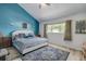 Main bedroom with a king-size bed and blue accent wall at 2599 Dolly Bay Dr # 308, Palm Harbor, FL 34684