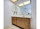 Bathroom featuring a vanity with wood cabinets and a large mirror at 10216 Regal Dr # 708, Largo, FL 33774