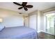Relaxing bedroom with a ceiling fan and sliding glass doors to a balcony at 10216 Regal Dr # 708, Largo, FL 33774