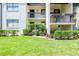 Well-maintained condominium building with lush green lawn and manicured shrubs at 2400 Winding Creek Blvd # 25-101, Clearwater, FL 33761