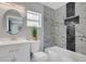 Modern bathroom with a white vanity, marble tile, and soaking tub at 1216 15Th S Ave, St Petersburg, FL 33705