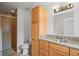 Bright bathroom featuring a granite countertop vanity, a mirror, and a tiled shower stall with glass doors at 1740 51St N St, St Petersburg, FL 33710