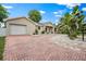 Inviting single-story home featuring an attached garage and a red brick driveway at 1740 51St N St, St Petersburg, FL 33710