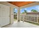 Covered outdoor patio with a wooden ceiling, railing, and a door leading to the interior at 1740 51St N St, St Petersburg, FL 33710