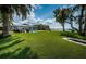 Large waterfront backyard with lush lawn, patio area, pool, and boat lift on the water at 4751 Baywood Point S Dr, Gulfport, FL 33711