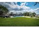 Spacious backyard with a swimming pool, patio, lush green lawn, and waterfront views at 4751 Baywood Point S Dr, Gulfport, FL 33711