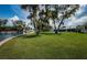 Green backyard with mature trees overlooking a waterfront at 4751 Baywood Point S Dr, Gulfport, FL 33711