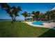 The backyard features waterfront views, a pool, and luscious green grass at 4751 Baywood Point S Dr, Gulfport, FL 33711