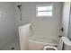 Bright bathroom features a window over the tub, shower with modern shower head, and a tiled wall at 4751 Baywood Point S Dr, Gulfport, FL 33711