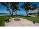 Backyard brick paver patio with fire pit, chairs and landscaping overlooking waterfront and bay at 4751 Baywood Point S Dr, Gulfport, FL 33711