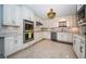 Well appointed kitchen with white cabinetry, stainless appliances, patterned backsplash and unique lighting at 4751 Baywood Point S Dr, Gulfport, FL 33711