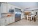 A spacious kitchen boasts stainless steel appliances, white cabinets, and an adjacent dining area at 4751 Baywood Point S Dr, Gulfport, FL 33711