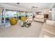 Bright living room with yellow chairs, neutral furniture and large sliding glass doors providing backyard pool views at 4751 Baywood Point S Dr, Gulfport, FL 33711