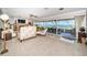 Elegant living room with a fireplace, comfortable seating, and expansive windows offering views of the pool and bay at 4751 Baywood Point S Dr, Gulfport, FL 33711