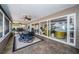 Enclosed sunroom with dining table, sofas, ceiling fans, and views of the backyard and bay at 4751 Baywood Point S Dr, Gulfport, FL 33711