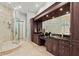 Bathroom boasts a glass shower, granite counters, and dark wood cabinetry, providing a luxurious experience at 774 Nina Dr, Tierra Verde, FL 33715