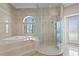 Luxurious bathroom featuring a glass-enclosed shower, soaking tub, and marble accents for a spa-like experience at 774 Nina Dr, Tierra Verde, FL 33715