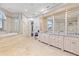 Elegant bathroom featuring dual vanities, a soaking tub, and travertine flooring at 774 Nina Dr, Tierra Verde, FL 33715