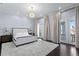 Bright bedroom with hardwood floors, stylish chandelier, and access to a private balcony with beautiful views at 774 Nina Dr, Tierra Verde, FL 33715