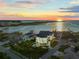 Aerial view of a luxurious home showcasing its waterfront location and stunning sunset views at 774 Nina Dr, Tierra Verde, FL 33715
