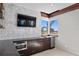 Kitchen featuring dark wood cabinetry, stainless steel appliances, modern backsplash, and a window view of palm trees at 774 Nina Dr, Tierra Verde, FL 33715
