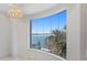 Open living space with curved picture window featuring coastal views, chandelier, and neutral paint colors at 774 Nina Dr, Tierra Verde, FL 33715
