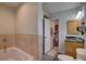 Bright bathroom with granite vanity, a soaking tub, and view to a walk in closet at 7809 Alafia Dr, Riverview, FL 33578